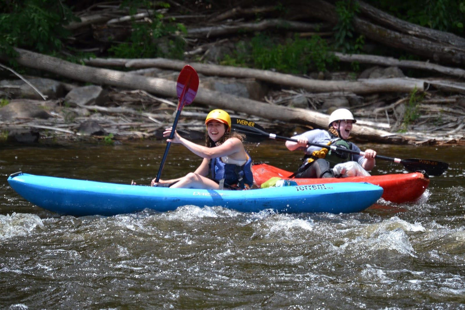 Whitewater Challengers: River guides in kayaks smiling at the camera